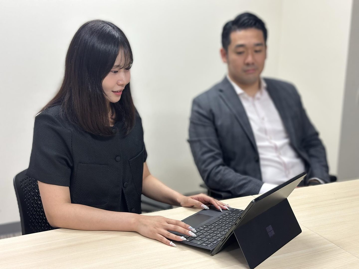 ノートPCで作業する春日井と、隣に座る森山